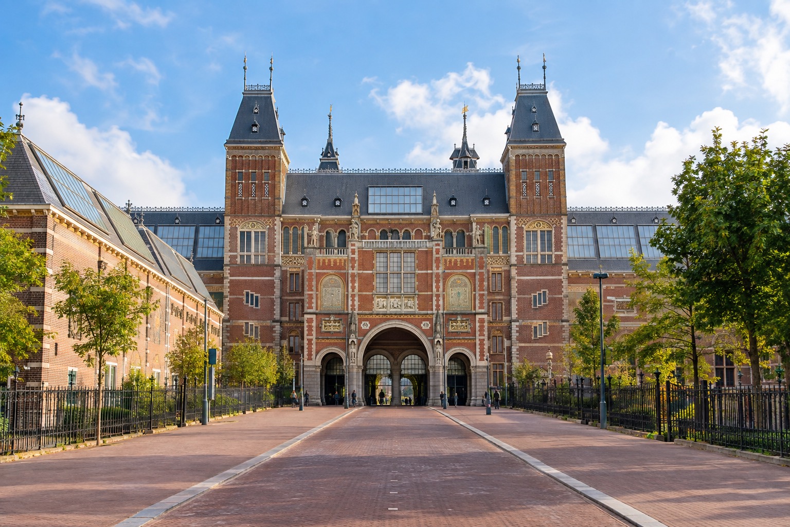 The Rijksmuseum's grand red-brick facade and entrance archway in Amsterdam